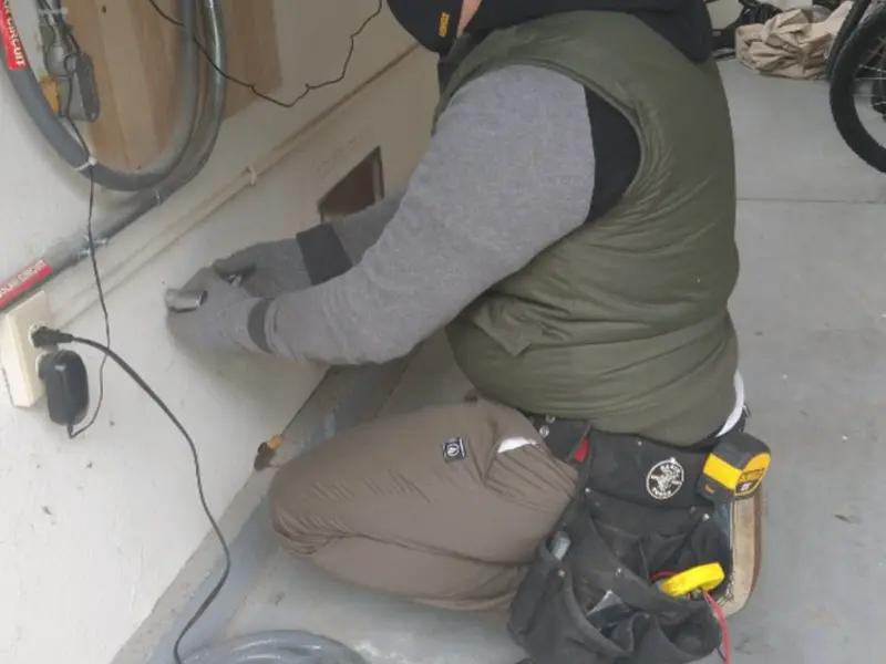 Electrician performing outlet wiring in a Winfield garage